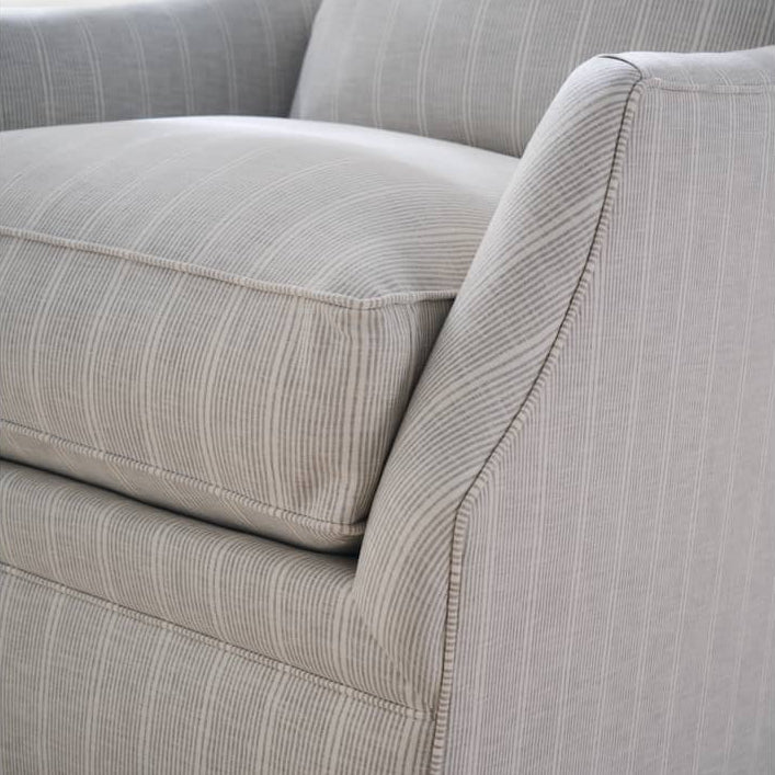 Gray striped sofa on a textured brown carpet
