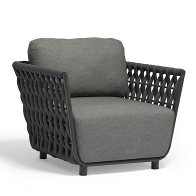 Beige wicker armchair with cream cushions on a white background