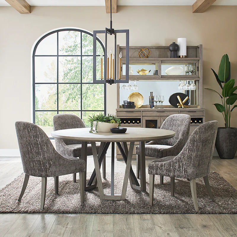 Dining room with round table and chairs, large window, and decorative elements.